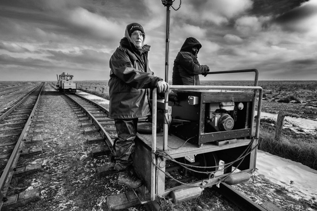 Claudia Nommensen auf Hallig Oland ist Wärterin des reetgedeckten Leuchtturms, weltweit einzigartig in dieser Form. Darüber hinaus betreibt sie eine kleine Landwirtschaft, vermietet eine Ferienwohnung und ein Fremdenzimmer und fährt ihre eigene Lore, mit der sie ihre Gäste und Einkäufe über das Watt bringt.