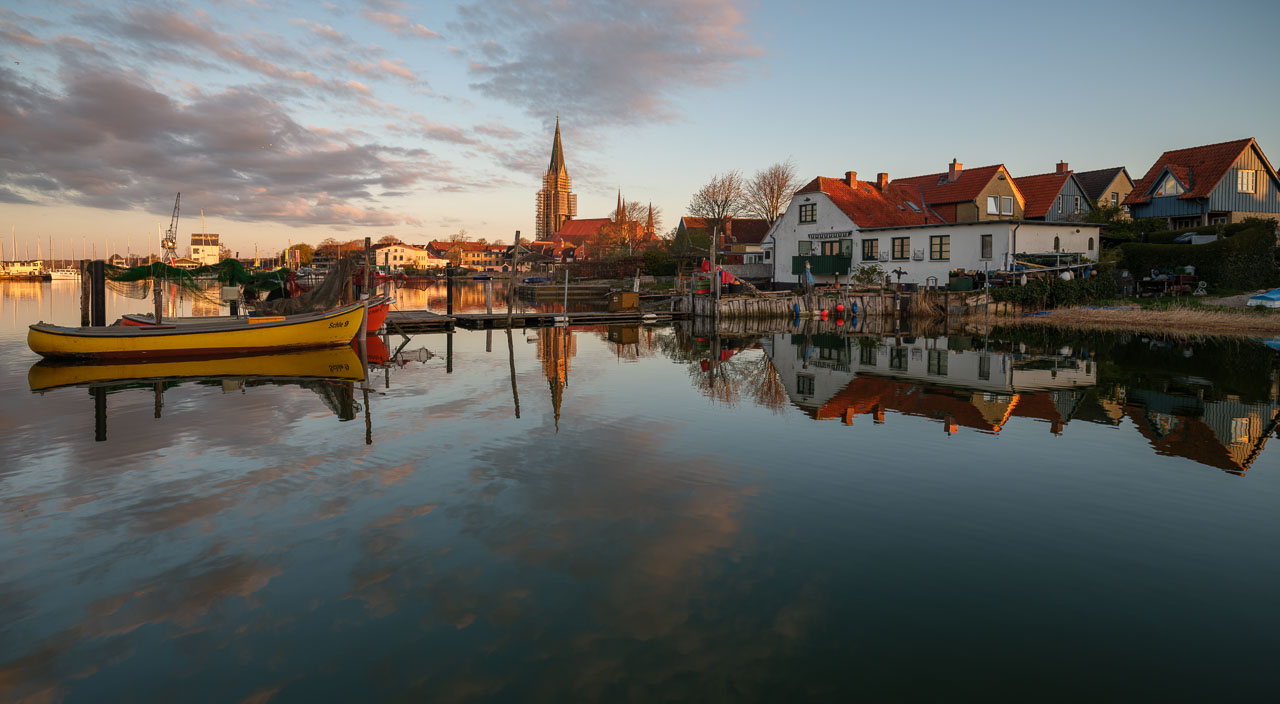 Frühes Morgenlicht setzt die Häuser, Boote und Brücken der Fischer auf dem Holm in Schleswig an der Schlei in Szene.