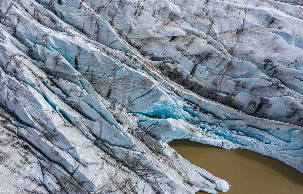 Die Gletscherzunge des Svínafellsjökull erstreckt sich weit in den gleichnamigen See, in dem Eisberge unterschiedlicher Größe treiben.