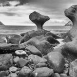 Wie eine von Menschenhand geschaffene Skulptur ragt der Fels Kannesteinen aus dem Meer hervor. Er befindet sich an der Küste der Insel Vågsøy im westlichen Norwegen. Der etwa vier Meter hohe Stein wurde im Laufe der Zeit durch die Gewalt des Meeres geformt. Digitale Infrarotaufnahme.