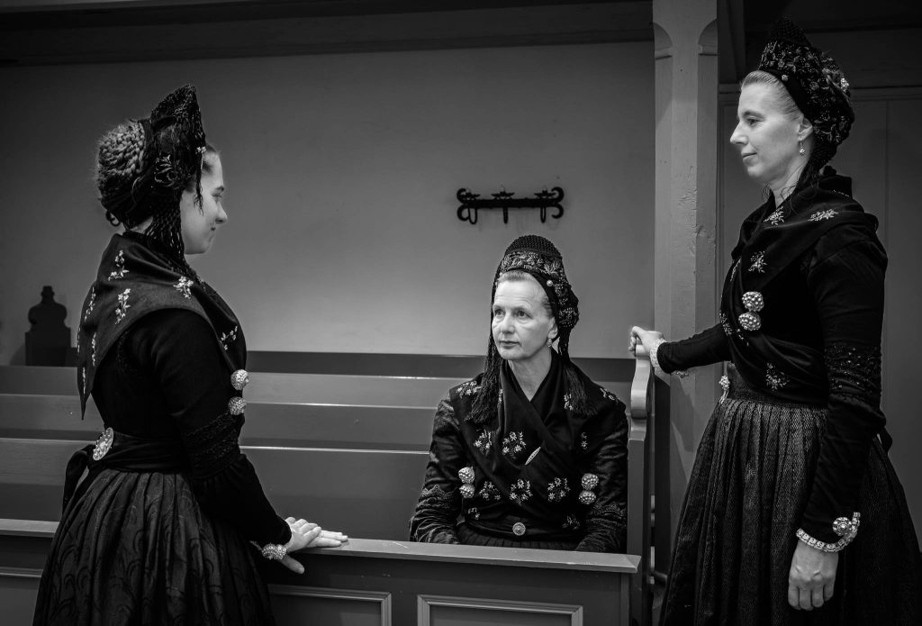 Mareike Böhmer, Helga Wögens und Kerstin Christiansen (v. l. n. r.) von der Utersumer Trachtengruppe im Friesendom in Nieblum in authentischer Föhrer Kirchgangstracht.