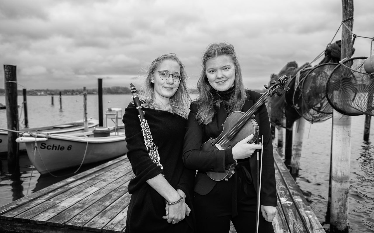 Olivia Wuttke (Klarinette) und Emilie Zwahr (Violine) sind Mitglieder des Landesjugendorchesters Schleswig-Holstein. Das Bild entstand am Ufer der Schlei in der Fischersiedlung Holm in Schleswig.
